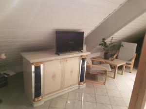 a living room with a tv on top of a cabinet at Gino s Ferienwohnung in Illingen