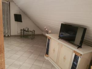 a living room with a flat screen tv on a dresser at Gino s Ferienwohnung in Illingen +4 photos