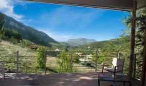 a chair on a balcony overlooking a valley at Gîte La Cerise Qui Rit in La Cresse +69 photos