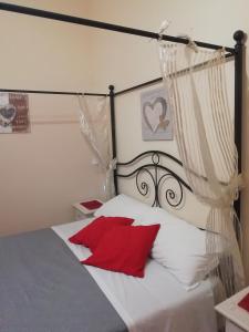 Un dormitorio con una cama en blanco y negro con almohadas rojas en City life Pompeii -Suite King Deluxe en Pompei