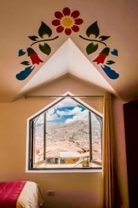 una camera da letto con finestra con fiori sul muro di Cusco Plaza Nazarenas a Cuzco