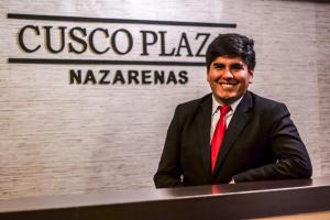 Un uomo in giacca e cravatta seduto a un tavolo di Cusco Plaza Nazarenas a Cuzco