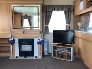 a living room with a tv and a fireplace at 8 Berth Sunnymede (Atlas) in Ingoldmells