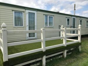 a white fence in front of a mobile home at 8 Berth Sunnymede (Atlas) in Ingoldmells