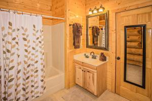 bagno con lavandino, doccia e specchio di Laurel Creek Hideaway a Gatlinburg