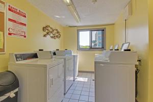 a waiting room with a row of washing machines at Plantation West Resort II in Gulf Shores