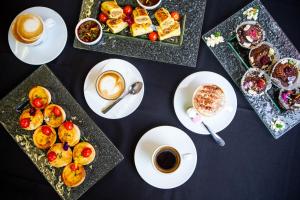 a table with plates of food and cups of coffee at Mercure Wellington Abel Tasman in Wellington