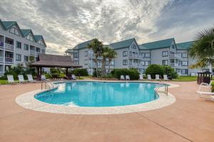 a large swimming pool in a courtyard with buildings at Plantation West Resort II in Gulf Shores