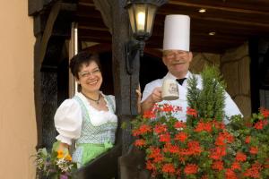 希爾塔赫的住宿－蘇姆維森羅斯勒酒店，一名男男女女和一名厨师站在阳台上