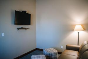 a room with a couch and a tv on a wall at The Lodge at Mauston in Mauston