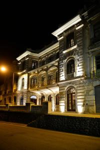 a large white building with lights on it at night at Hotel Cruz del Vado in Cuenca