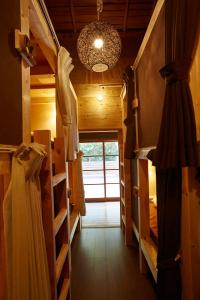 un corridoio con letti a castello e lampadario pendente di Guest House Preta Torami a Ichinomiya