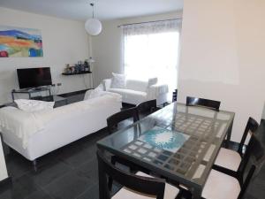 a living room with a glass table and a white couch at Marfolin 11 Beach Front apartment with sea views from every room in Cotillo +11 photos