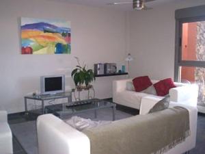 a living room with two white couches and a tv at Marfolin 11 Beach Front apartment with sea views from every room in Cotillo