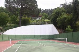 a tennis court with a tennis net on it at Quinta das Leiras in Santo Tirso