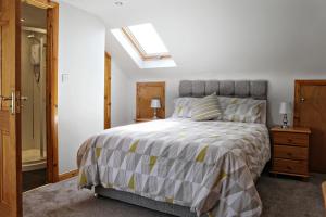 a bedroom with a bed and a skylight at Aunt Rachel's Cottage in Bushmills