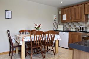 a kitchen with a table and chairs and a kitchen with a counter at Aunt Rachel's Cottage in Bushmills