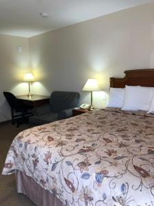 una camera d'albergo con letto, scrivania e sedia di Royal Napanee Inn a Napanee