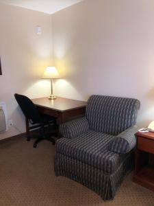 a living room with a couch and a desk with a lamp at Royal Napanee Inn in Napanee