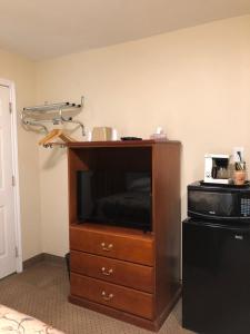 a entertainment center with a tv and a microwave at Royal Napanee Inn in Napanee