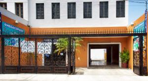 un edificio de color naranja y blanco con una puerta abierta en Casa NE en Mérida