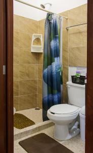 a bathroom with a toilet and a shower curtain at Casa NE in Mérida