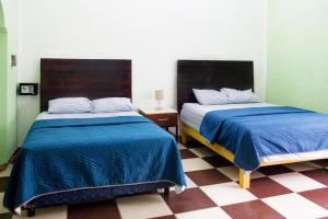 - deux lits assis l'un à côté de l'autre dans une pièce dans l'établissement Casa NE, à Mérida