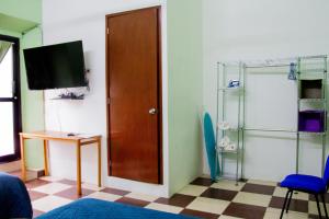 a room with a door and a table and a tv at Casa NE in Mérida