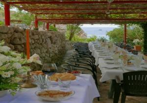 a row of tables with plates of food and wine at Rijeka Rezevici Apartment in Reževići