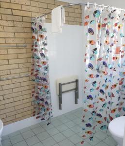 a bathroom with a shower curtain with fish on it at Beerwah Motor Lodge in Beerwah +25 photos