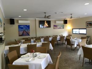 Footprints Preston Beach في بريستون بيتش: غرفة طعام مع طاولات وكراسي بيضاء