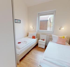 a small room with two beds and a mirror at Feriendorf Südstrand Haus 40 in Pelzerhaken