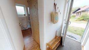 a hallway with a door leading to a bathroom with a window at Feriendorf Südstrand Haus 40 in Pelzerhaken +17 photos