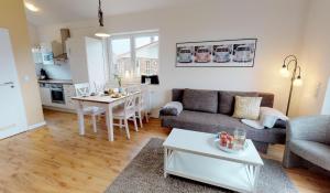 ein Wohnzimmer mit einem Sofa und einem Tisch in der Unterkunft Feriendorf Südstrand Haus 40 in Pelzerhaken