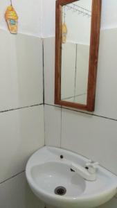 a bathroom with a white sink and a mirror at ADELYA HOMESTAY in Praya
