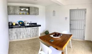 a kitchen with a wooden table and white chairs at Maracaibo View in Providencia