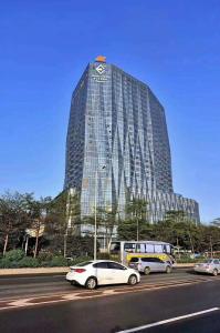 a tall building with cars parked in front of it at Estandon Hotel Guangzhou in Guangzhou