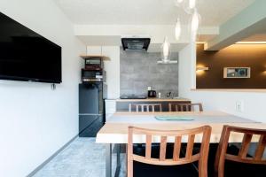 a kitchen with a table and two chairs and a tv at Hotel Kado Gosho-Minami Kyoto in Kyoto