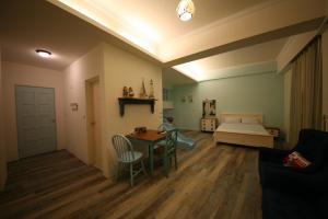 ein Wohnzimmer mit einem Tisch, Stühlen und einem Bett in der Unterkunft RUBATO B&B in Hualien