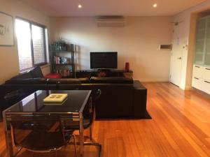 a living room with a couch and a table at Parklane Apartments in Fremantle