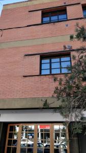 a red brick building with windows on the side of it at Rosa Ramona Rooms in San Salvador de Jujuy