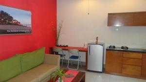a living room with a couch and a table and a kitchen at The Green Zhurga Suite in Kerobokan