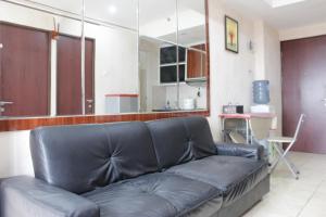 a black leather couch in a living room at Cozy 2BR Tamansari Panoramic Apartment By Travelio in Bandung