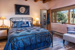a bedroom with a blue bed and a window at Bobcat Inn in Santa Fe