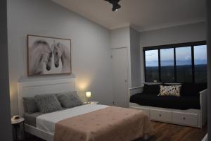 1 dormitorio con cama y ventana en Ironbark House, en Dimbulah