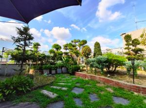 a garden with grass and trees and an umbrella at OYO Hostel Myeongdong 2 in Seoul