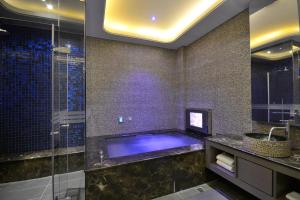 a bathroom with a large tub and a large mirror at Hea Duenn Motel in Taichung