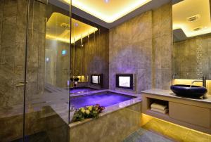 a bathroom with a large mirror and a large tub at Hea Duenn Motel in Taichung
