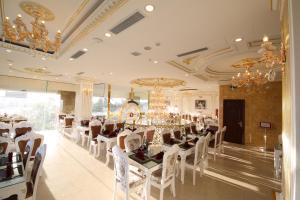 a dining room with a long table and white chairs at Tuyet Son Hotel (TS Ocean Hotel) in Da Nang