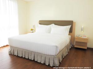 Tempat tidur dalam kamar di d'primahotel Panakkukang Makassar (Formerly Fave Panakkukang)